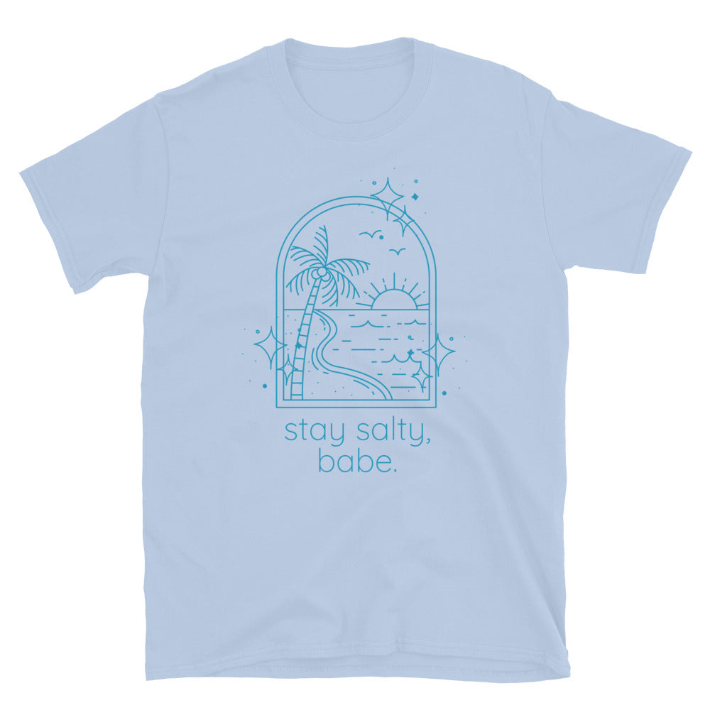 Light blue women’s graphic t-shirt with beach scene and text that reads "stay salty, babe" laid flat on white background