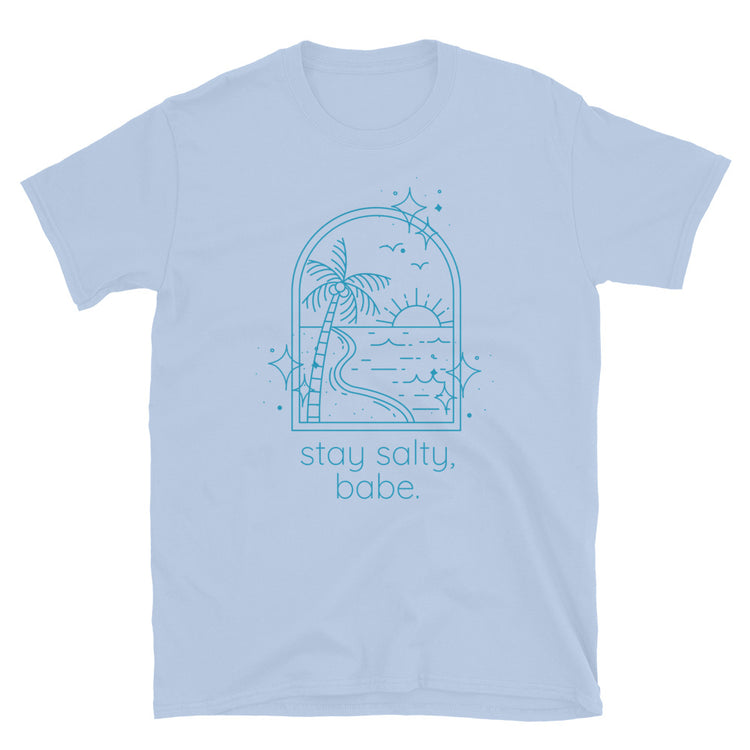 Light blue women’s graphic t-shirt with beach scene and text that reads "stay salty, babe" laid flat on white background