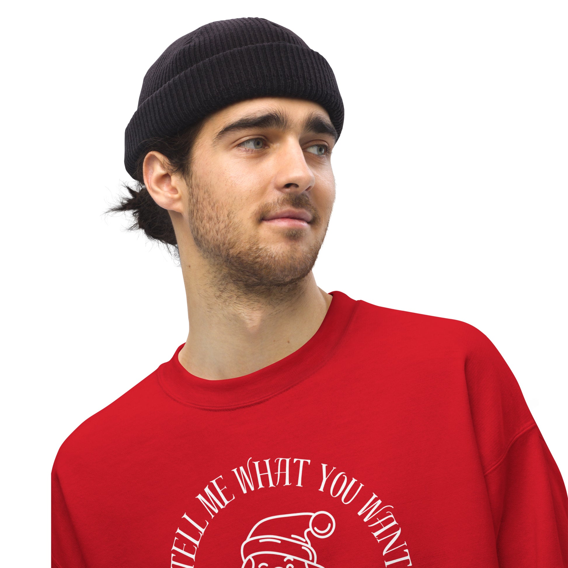 Man wears a beanie and a red crewneck sweatshirt featuring Santa's face and text that reads "So Tell Me What You Want What You Really Really Want," playfully referencing the Spice Girls song while incorporating holiday humor.