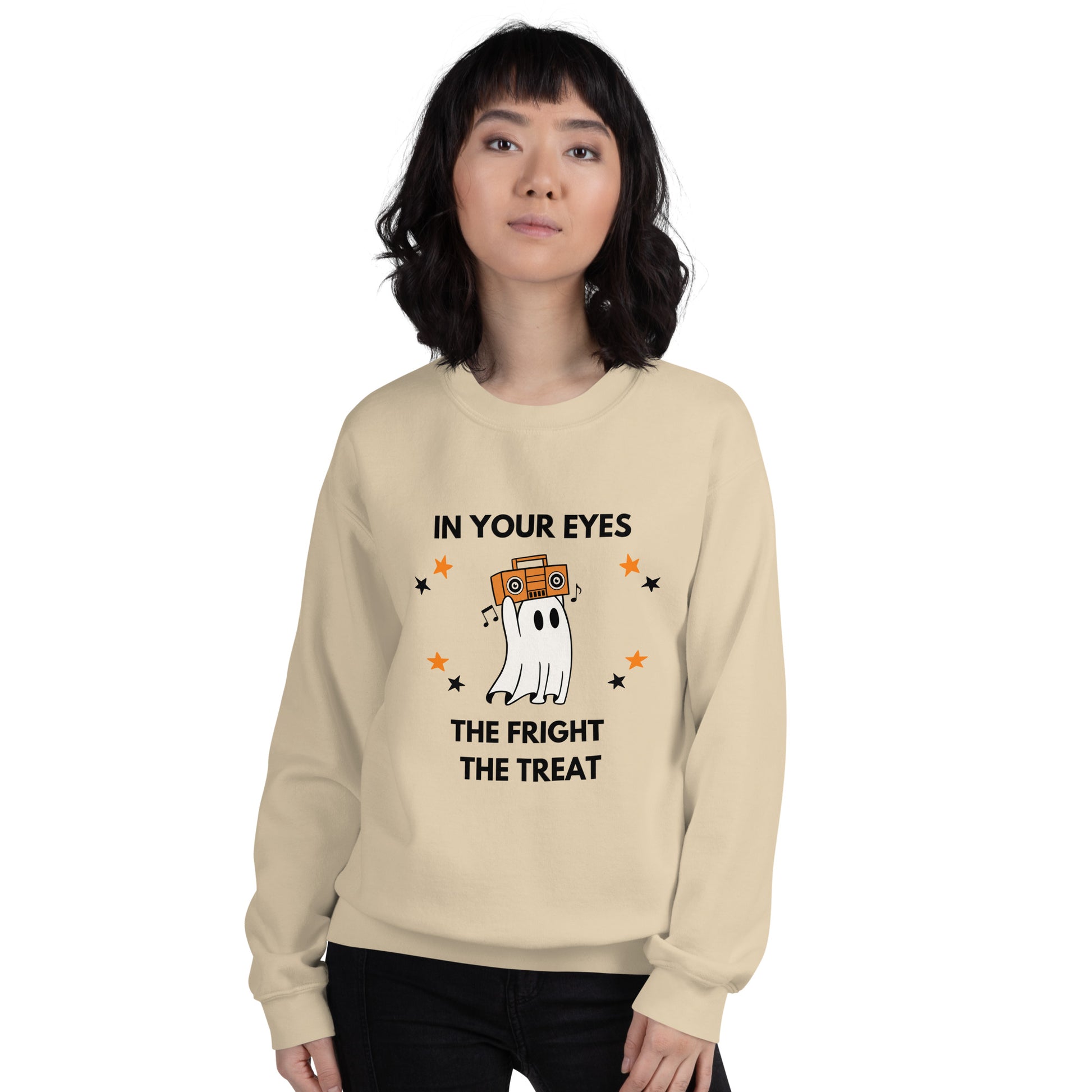 Woman with short dark hair wears a Halloween sweatshirt featuring a ghost holding an orange boombox overhead, Say Anything style. The shirt reads "In your eyes - The Fright, The Treat."