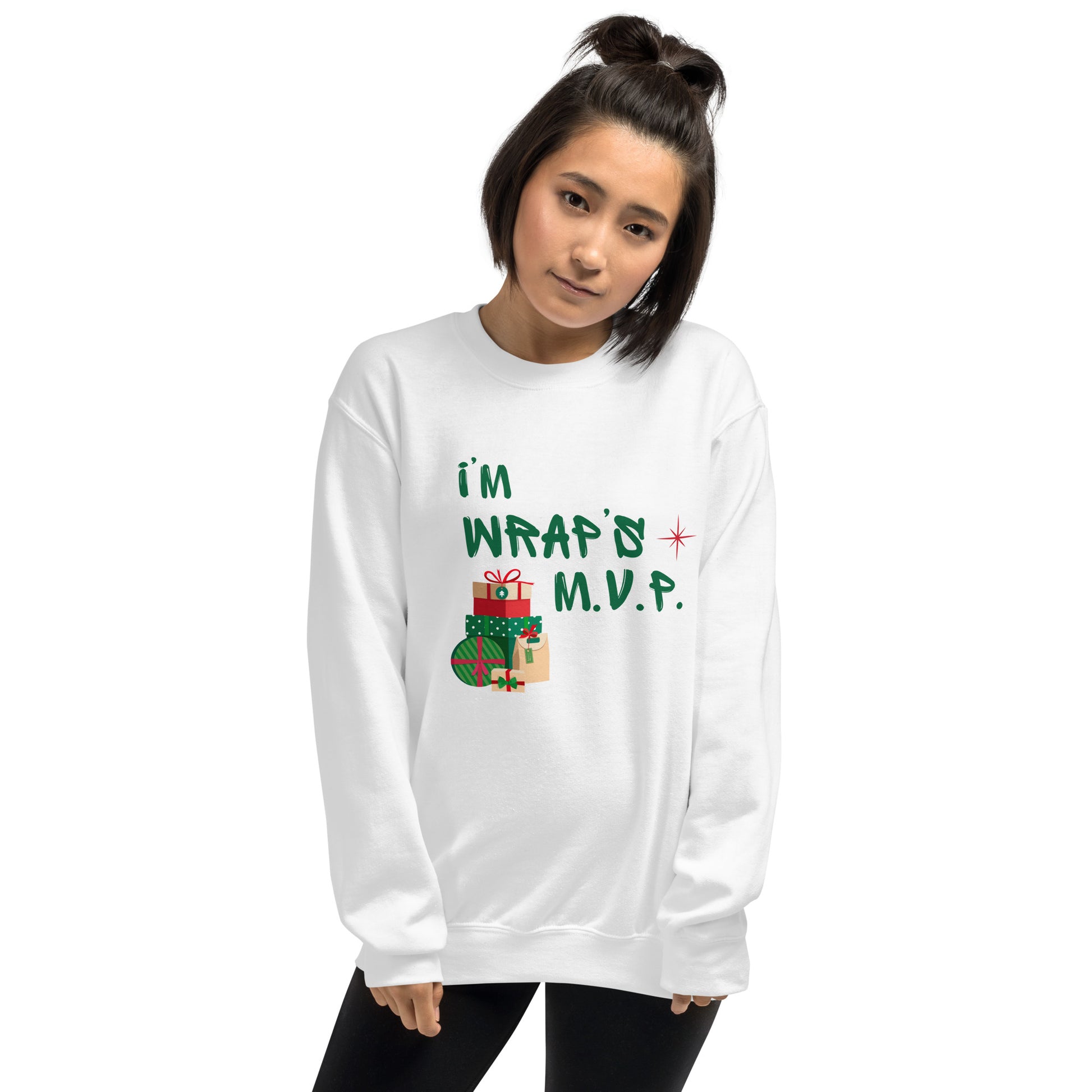 Woman wears cozy white crewneck sweatshirt with green text reading 'I'M WRAPs M.V.P.' and festive gift icons. A humorous Christmas play on words for holiday gift-wrapping enthusiasts.