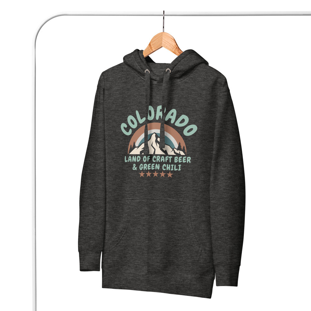 A gray Colorado hoodie hangs on a wooden hanger against a white background. The comfy hoodie features a retro mountain design and references craft beer and green chili.