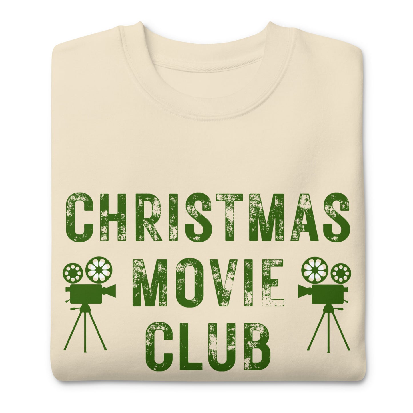 Cream colored crewneck sweatshirt with distressed green text reading 'CHRISTMAS MOVIE CLUB', decorated with retro movie camera icons. Perfect for holiday movie marathons.