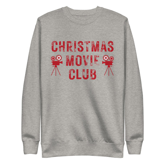 Heather gray crewneck sweatshirt with distressed red text reading 'CHRISTMAS MOVIE CLUB', decorated with retro movie camera icons. Perfect for holiday movie marathons.