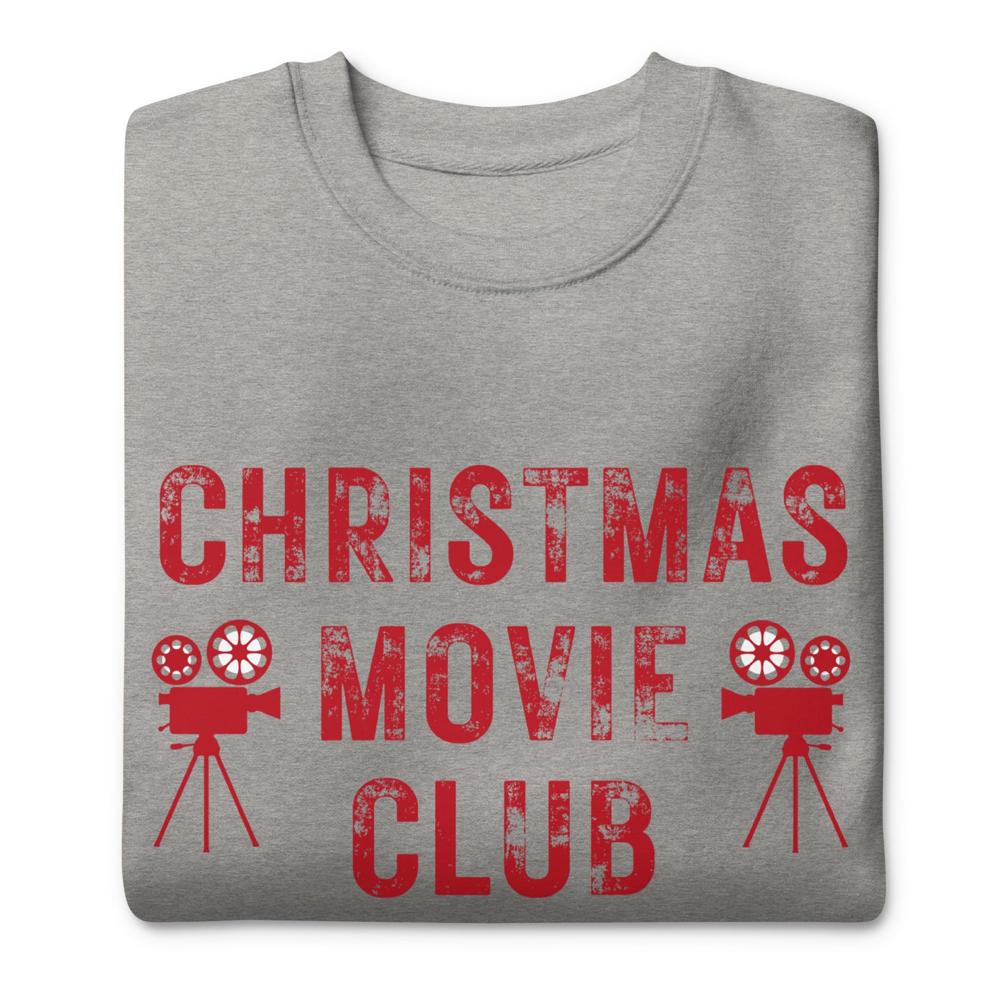 Heather gray crewneck sweatshirt with distressed red text reading 'CHRISTMAS MOVIE CLUB', decorated with retro movie camera icons. Perfect for holiday movie marathons.