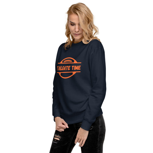 Woman sports a blue and oragne football sweatshirt. The blue crewneck displays an oraange football graphic with the word "tailgate time" in distressed orange font.