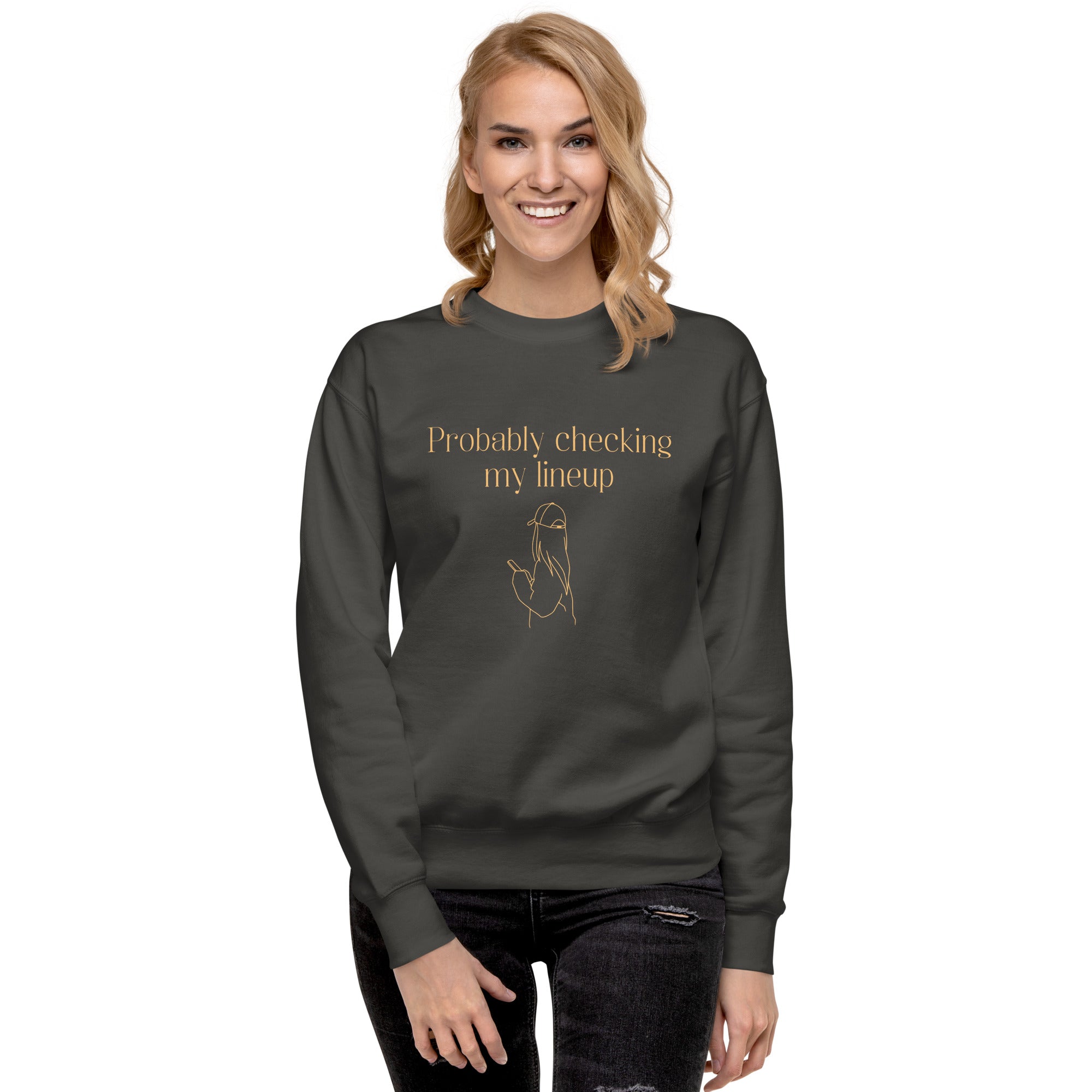 Smiling woman wears a fantasy football sweatshirt that says "probably checking my lineup" It features line art of a woman in a baseball cap looking at your phone.