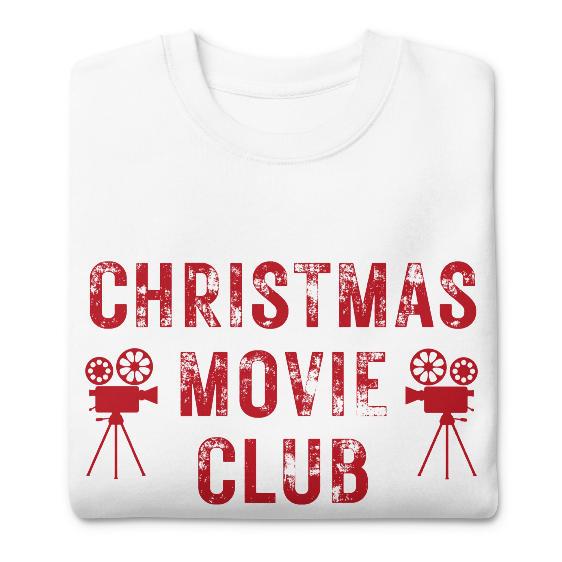 White crewneck sweatshirt with distressed red text reading 'CHRISTMAS MOVIE CLUB', decorated with retro movie camera icons. Perfect for holiday movie marathons.