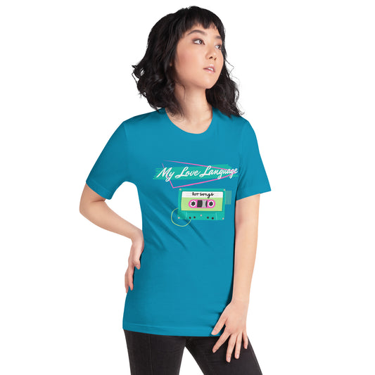 A woman wears a bright royal blue tee that features bright pink and green graphics from the 80s and 90s. The shirt reads "MY LOVE LANGUAGE" and features a cassette tape - a reference to the mixtape era.