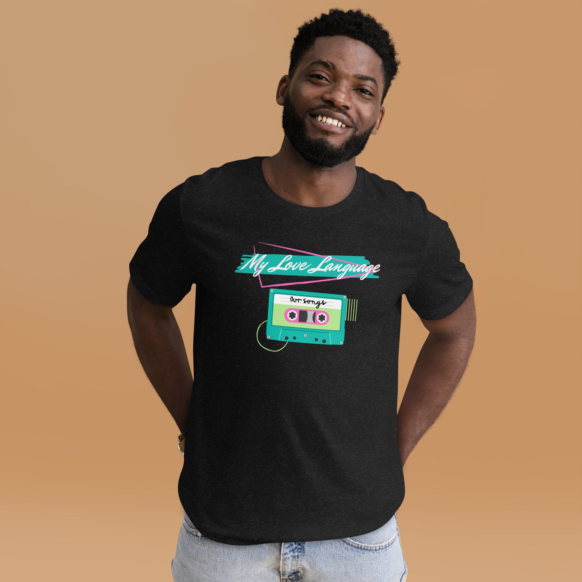 A smiling man wears a black tee that features bright aqua, pink and neon green graphics from the 80s and 90s. The shirt reads "MY LOVE LANGUAGE" and features a cassette tape - a reference to the mixtape era.