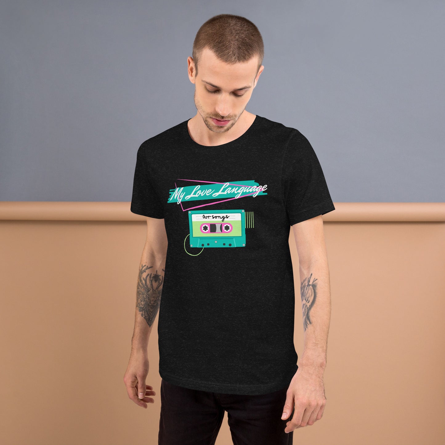 A man with tattooed arms wears a black tee with bright pink, blue, yellow and green graphics from the 80s and 90s. The shirt reads "MY LOVE LANGUAGE" and features a cassette tape - a reference to the mixtape era.