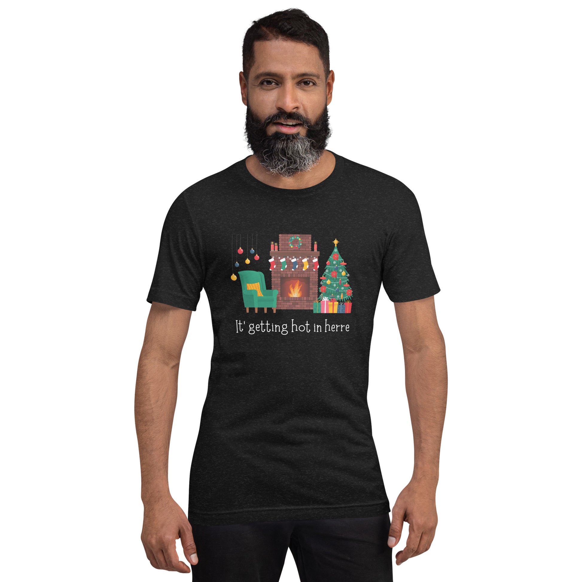 Man wears festive holiday tee shirt that reads "It's getting hot in herre". The design is a cozy Christmas living room with holiday decorations and a roaring fireplace.