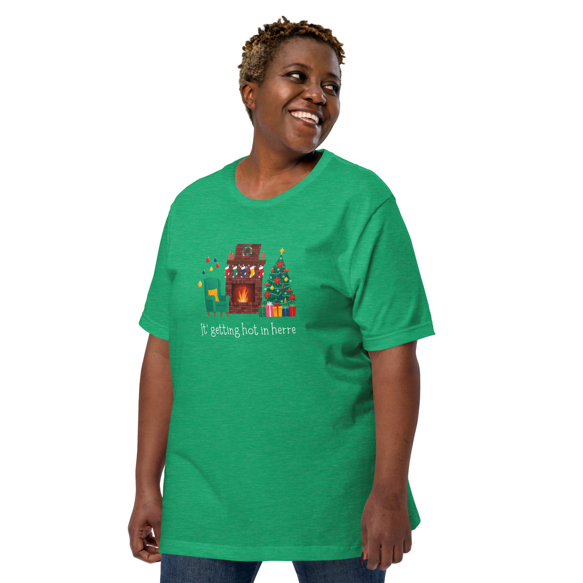 Woman wears festive holiday tee shirt that reads "It's getting hot in herre". The design is a cozy Christmas living room with holiday decorations and a roaring fireplace.