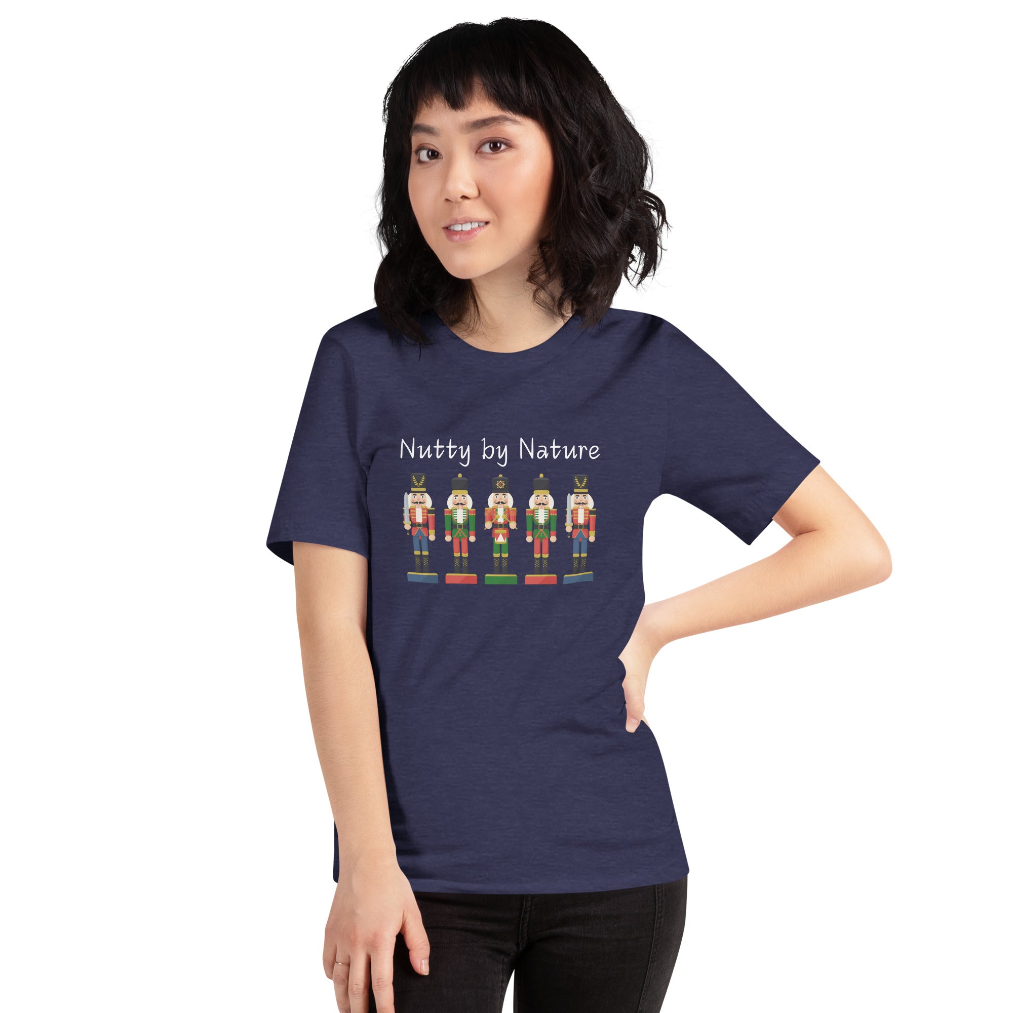 Woman wears a festive and playful holiday shirt featuring five nutcrackers and text that reads "Nutty by Nature"