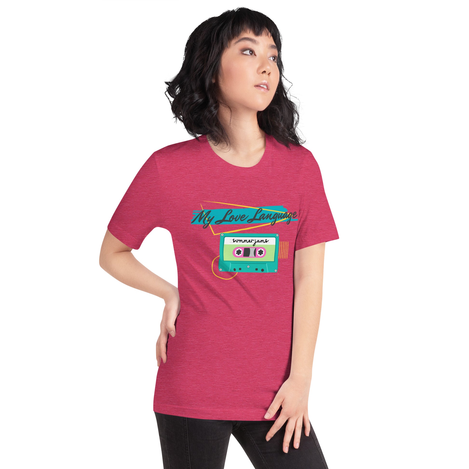 A woman wears a hot pink tee with bright pink, blue, yellow and green graphics from the 80s and 90s. The shirt reads "MY LOVE LANGUAGE" and features a cassette tape - a reference to the mixtape era.