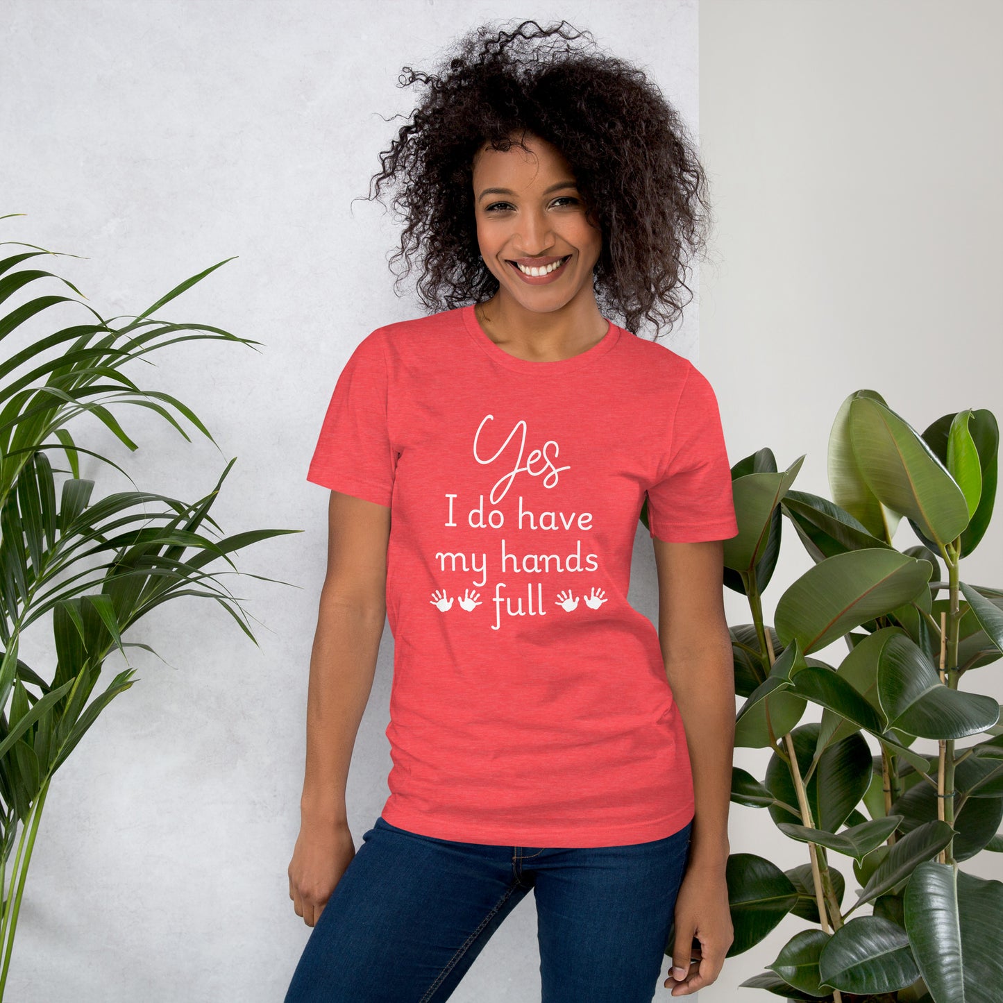 Smiling woman wears a heather red tee that says 'Yes, I do have my hands full' with two sets of child handprints.