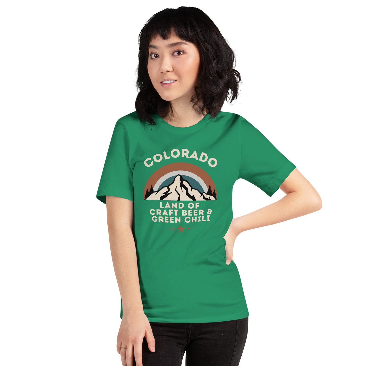 Smiling woman with short, dark hair wears a graphic tee that says "COLORADO: Land of Craft Beer & Green Chili".  The shirt includes a scenic view of the mountains with a colorful sky.