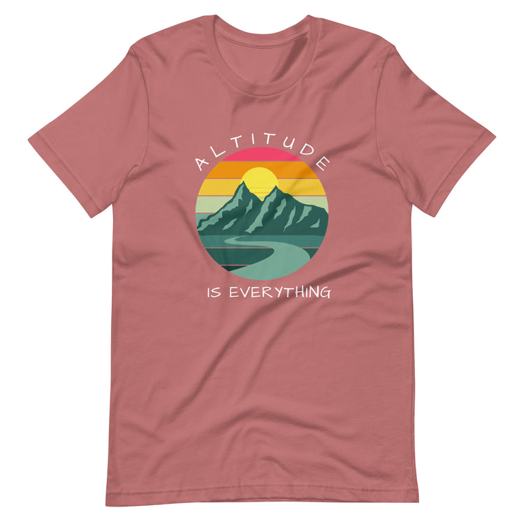Dusty rose pink graphic tee reads "ALTITUDE IS EVERYTHING" round a colorful image of mountains and a beautiful sunset.