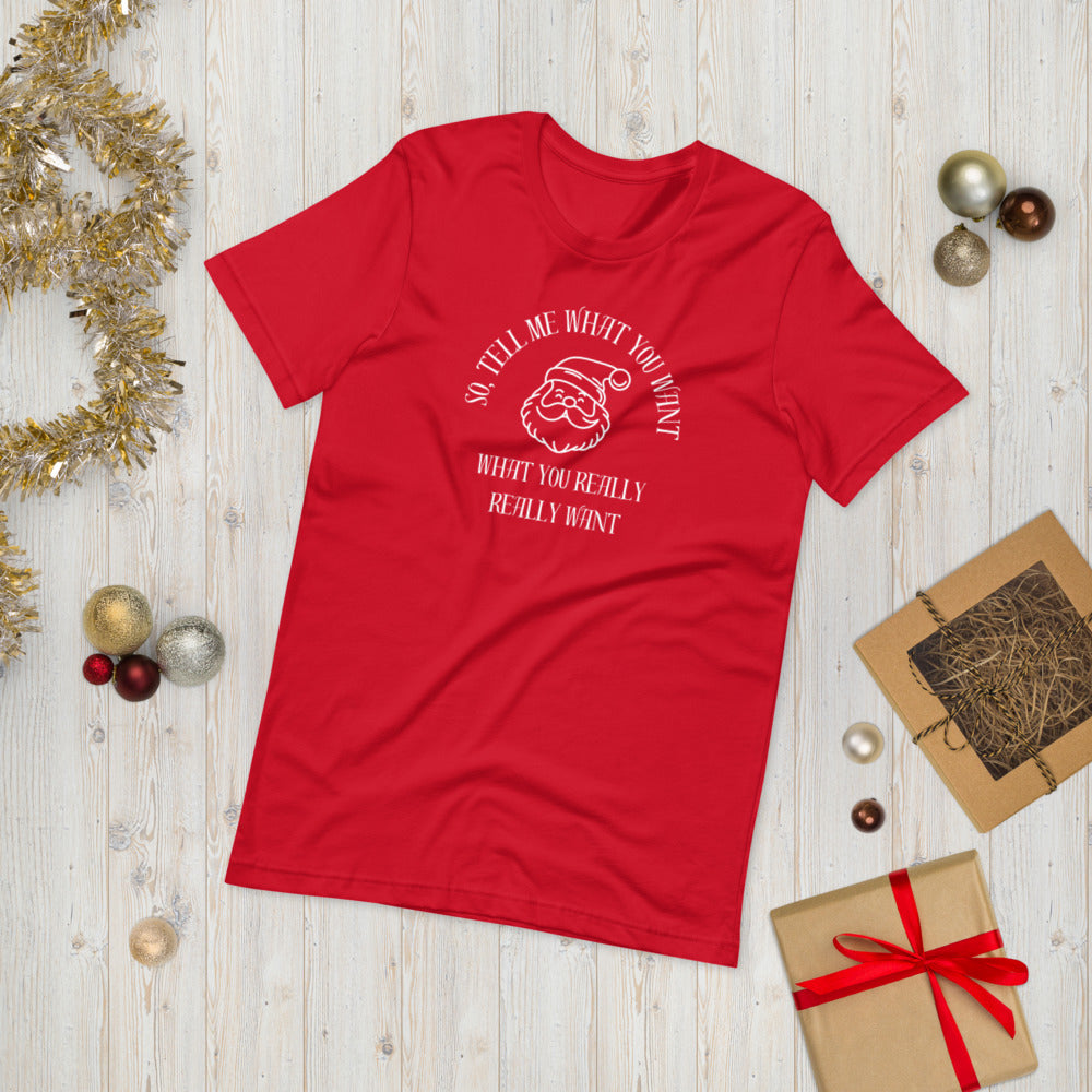 Festive red unisex tee shirt featuring Santa's face and the text "So Tell Me What You Want What You Really Really Want"