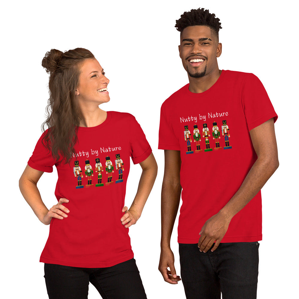 Man and woman wear matching festive and playful holiday shirts featuring five nutcrackers and text that reads "Nutty by Nature"
