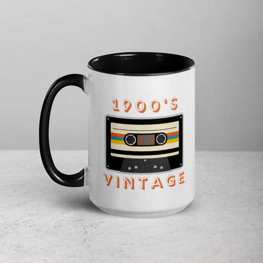 White ceramic mug with black interior and black handle sits on a white surface. It displays a retro looking cassette tape and the words "1900s VINTAGE". A Jade Street Market original.