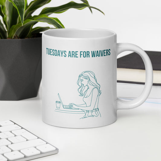 White ceramic mug sits on a white desk beside a laptop and plant. It displays line art graphic of a woman working at a laptop and the text reads "TUESDAYS ARE FOR WAIVERS". It's a playful spin on Fantasy Football Managers who spend Tuesdays doing research and strategy before the waiver wire deadline.