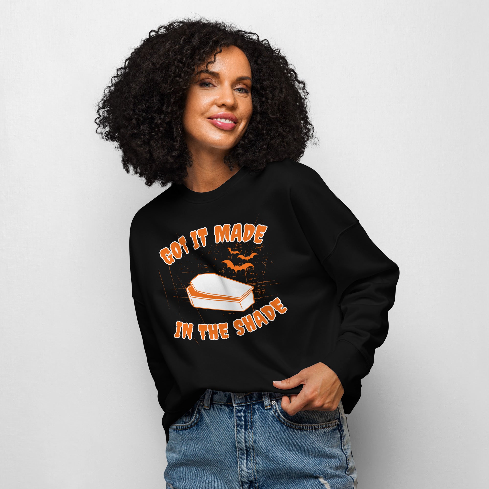 Smiling woman sports unique distressed halloween sweatshirt that says "Got it made in the shade" with a vampire coffin and bats.
