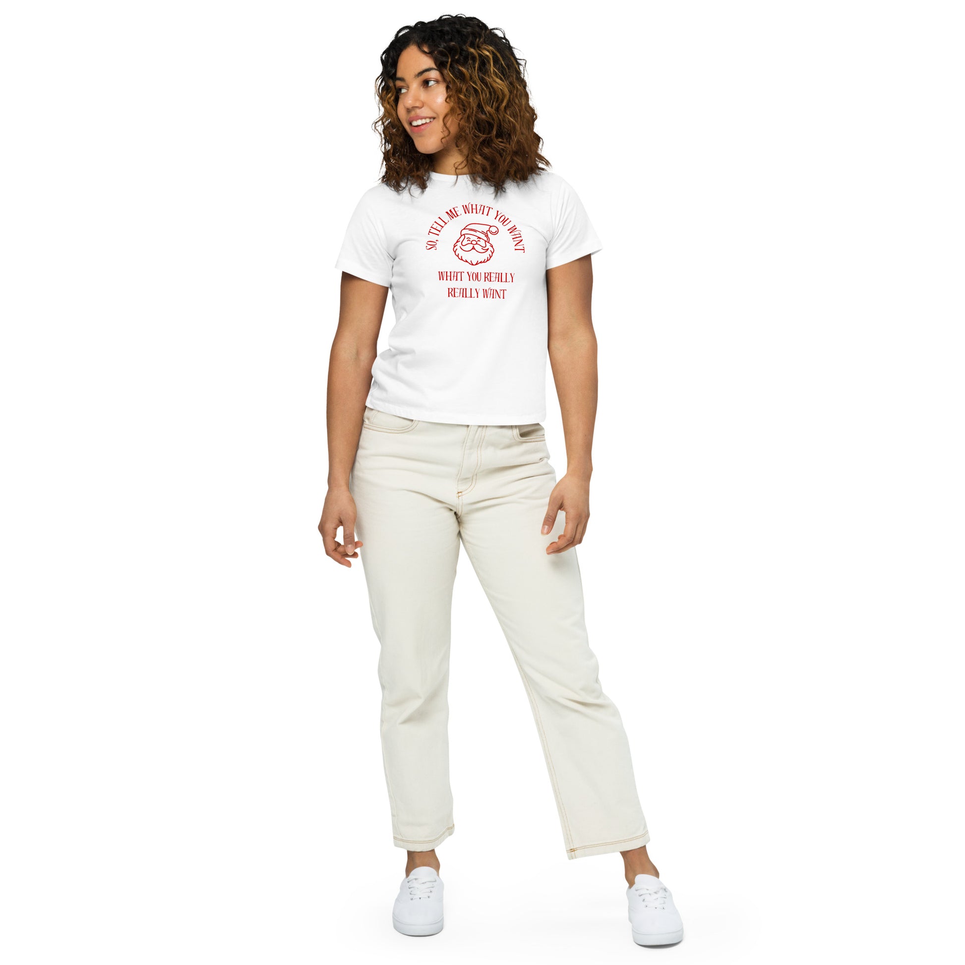 A woman models a fitted white mid-length t-shirt featuring Santa's face and the text "So Tell Me What You Want What You Really Really Want" in red, perfectly hitting at the waistline of her pants.