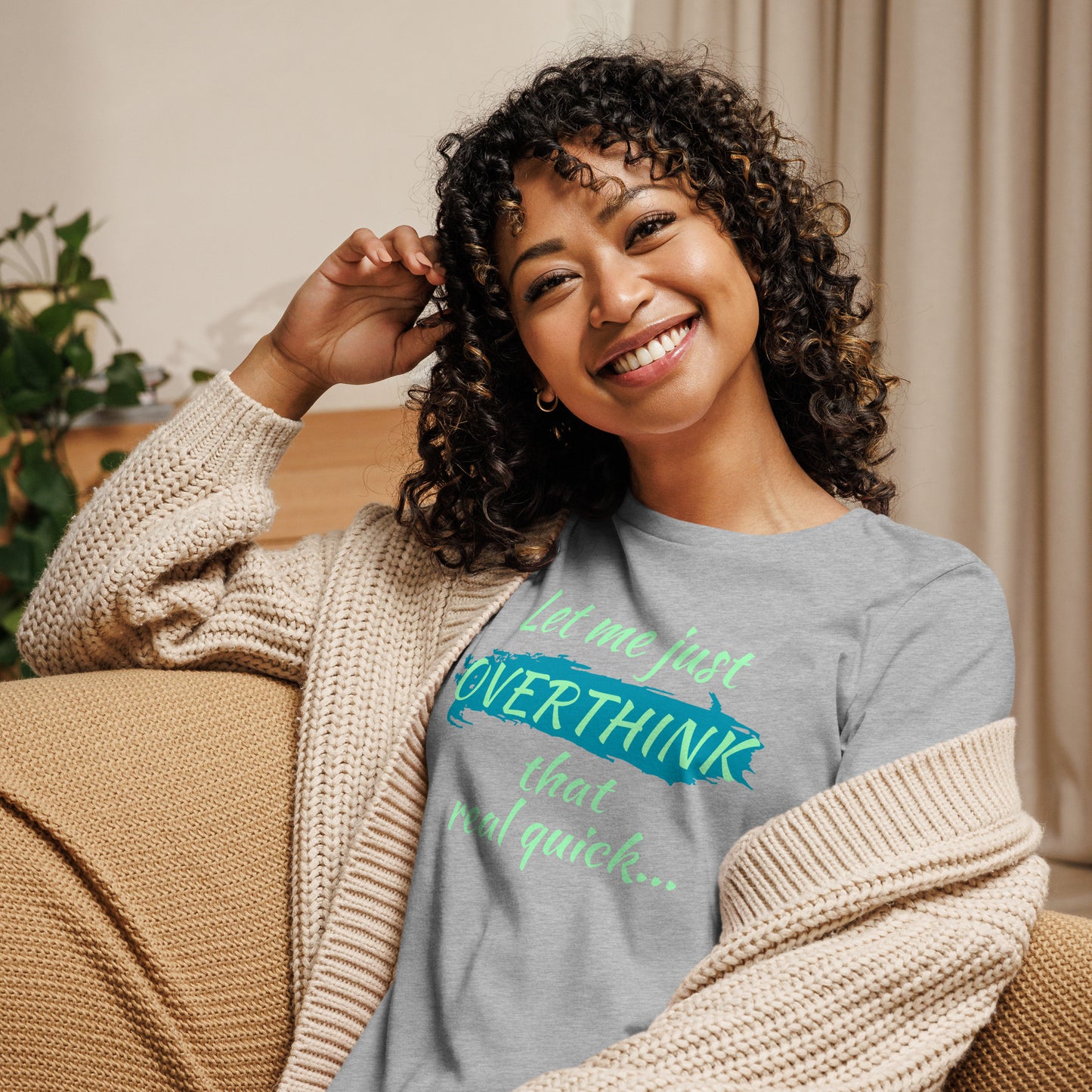 Smiling woman in a gray overthinkers tee with vibrant green and blue lettering — humorous women’s mental health shirt.