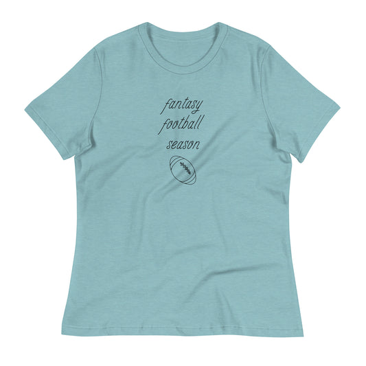 Light blue women's tee shirt that reads "FANTASY FOOTBALL SEASON" along with an image of a football. The font is a thin and flowy cursive that is pretty and feminine.