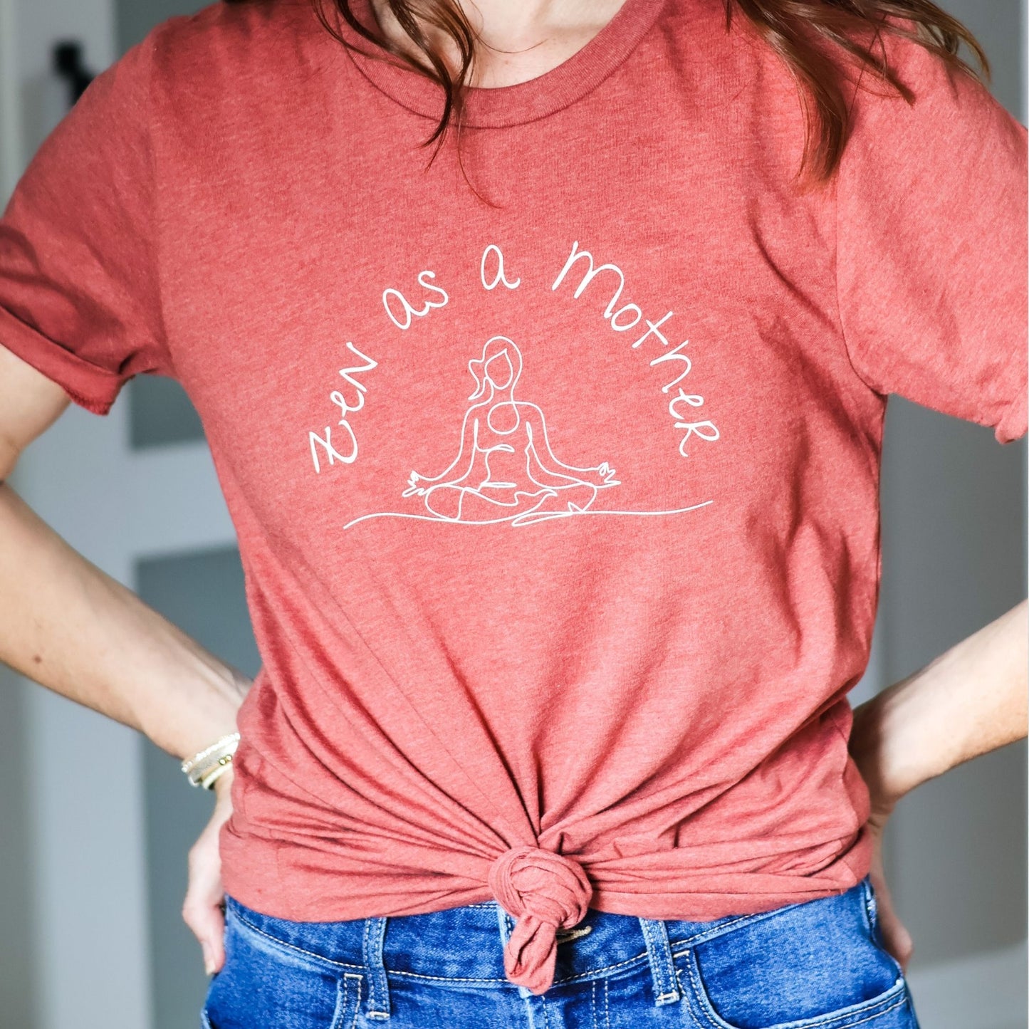 Close up of a heather clay colored t-shirt that reads Zen As A Mother with a cute front knot