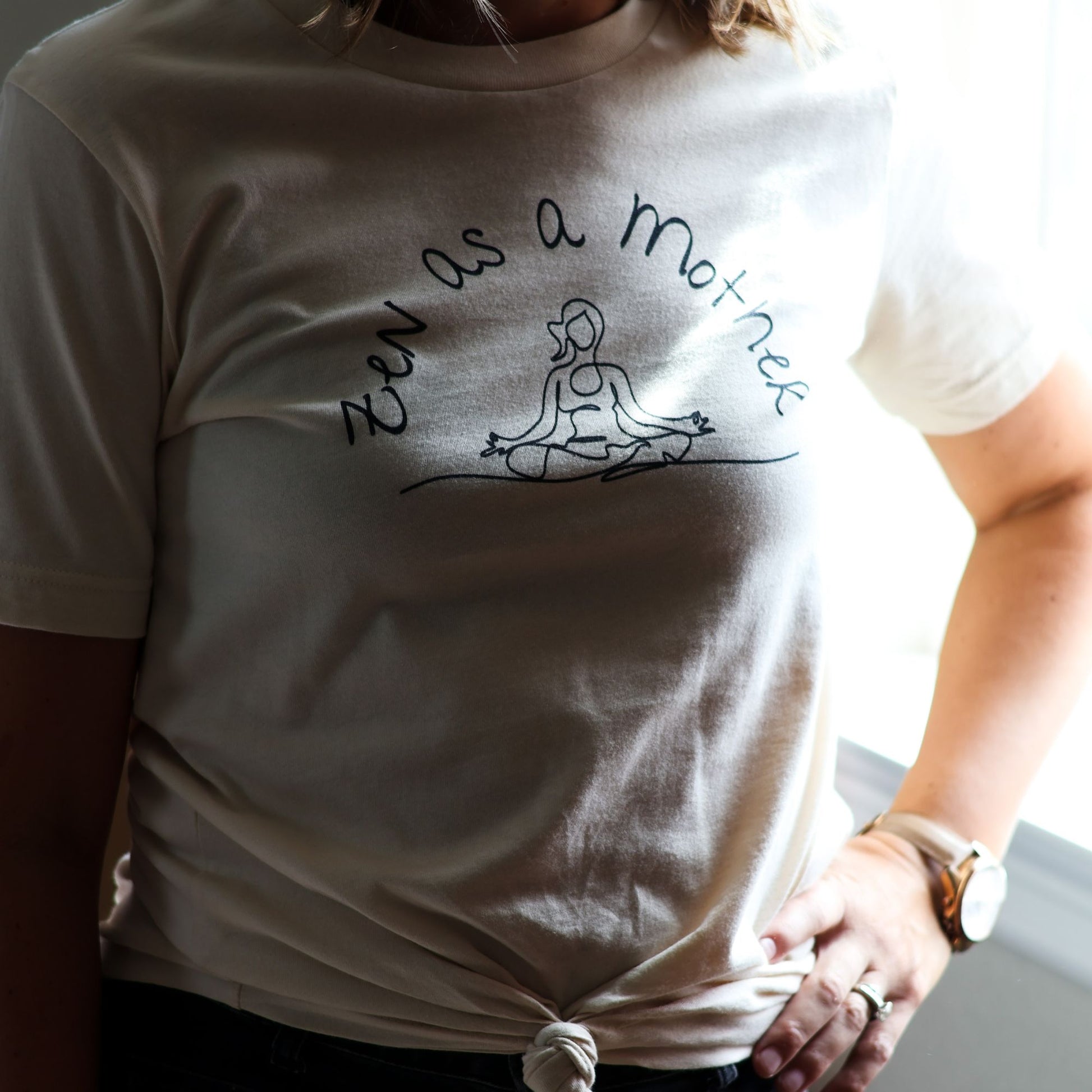 Woman wears Zen as Mother tee styled with front knot and wristwatch